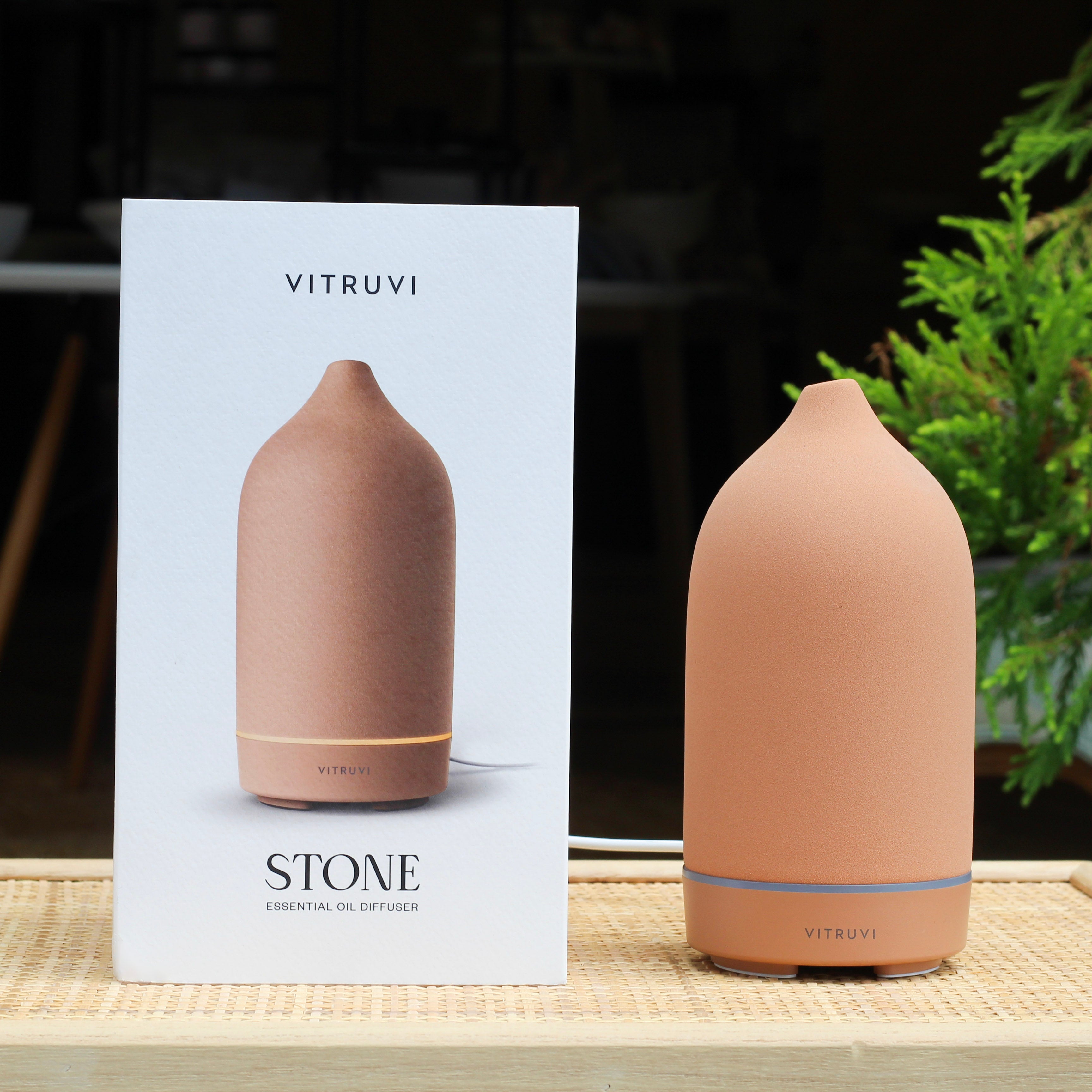 Vitruvi Stone essential oil diffuser on a table with packaging in the background