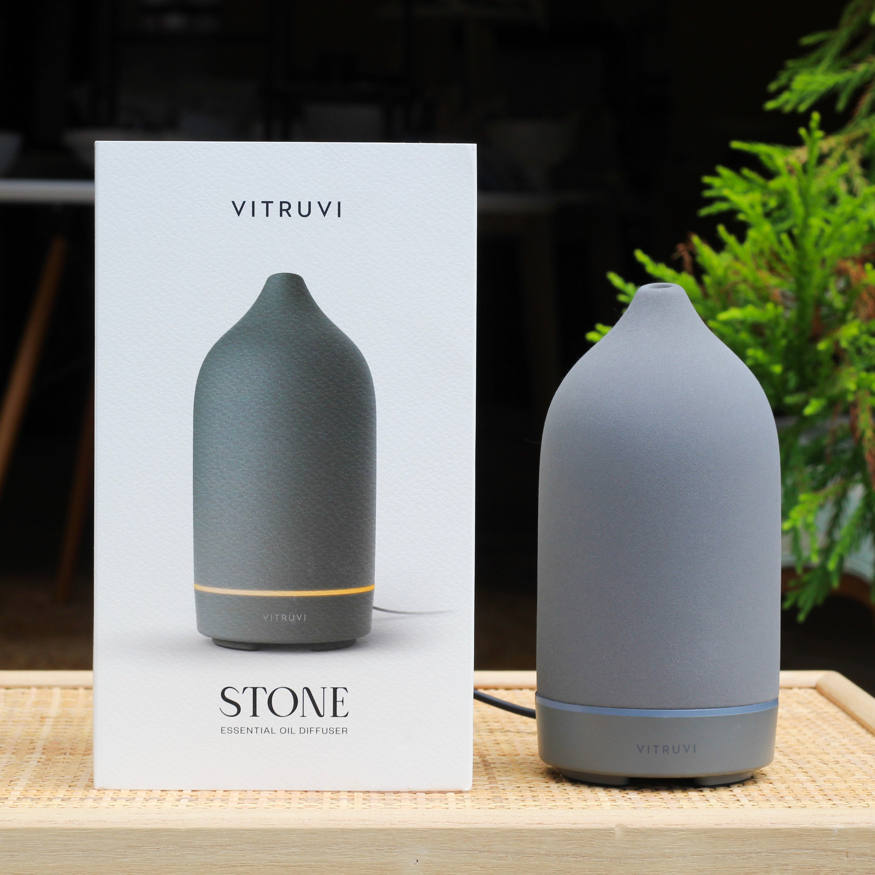 Gray diffuser with Vitruvi packaging on a wooden surface